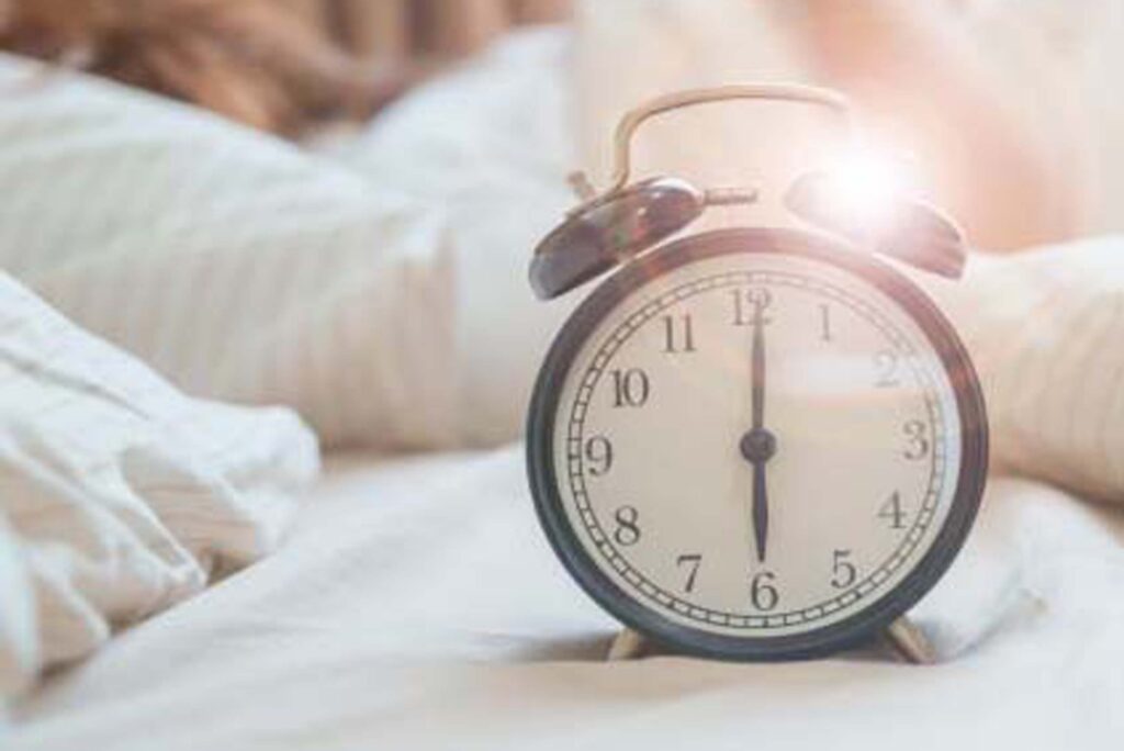 alarm clock with asian woman in bed while sleeping, young adult female wake up late in the early morning. Relaxing , sleepy, daily routine and have a nice day concepts